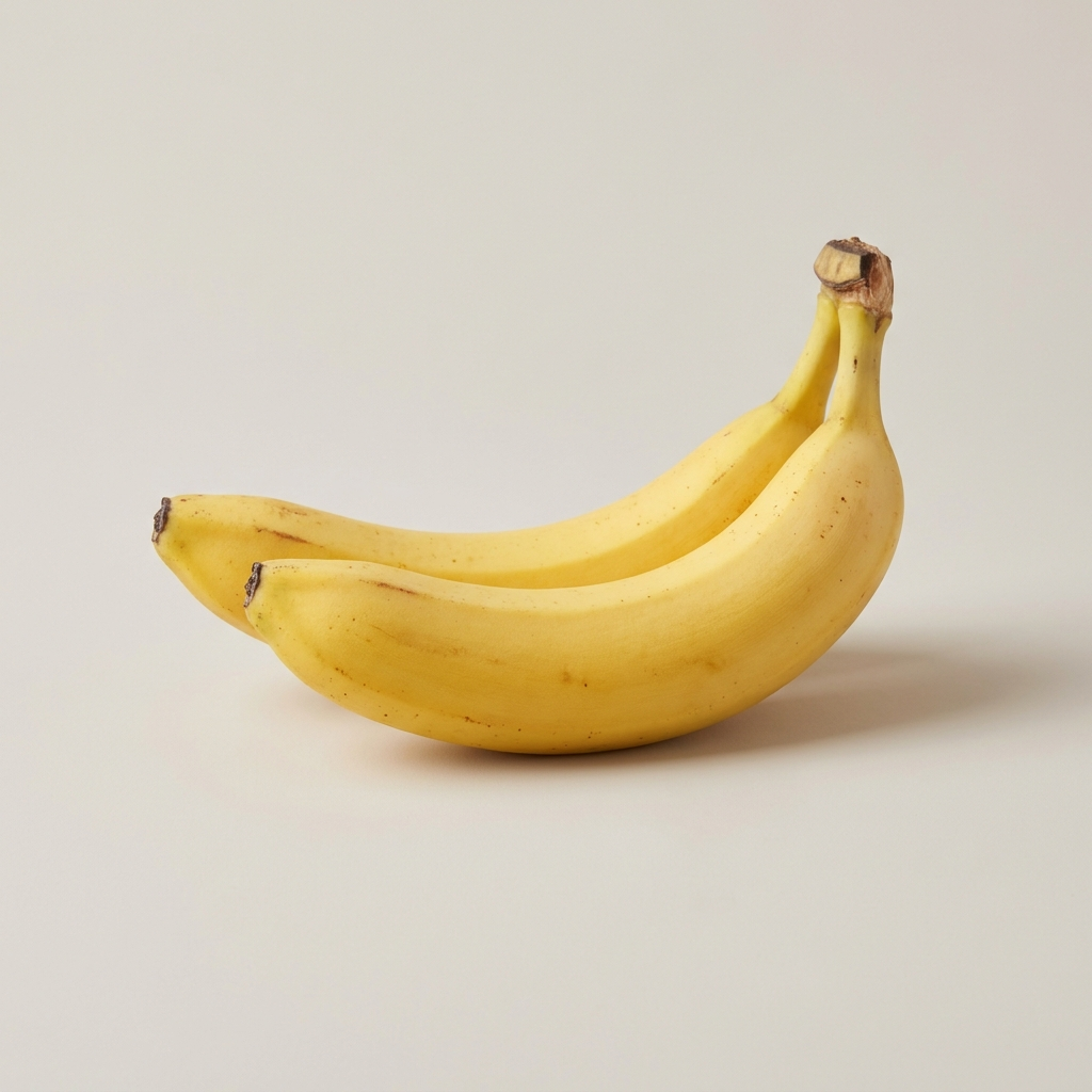Two ripe bananas on a pale studio background